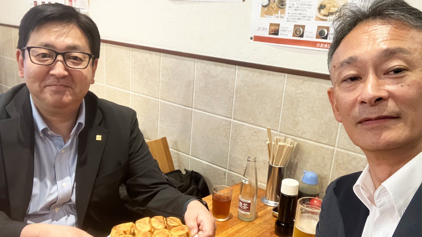 長年の仲間である間中幸治FPとホワイト餃子を食べる和田洋FPの写真
