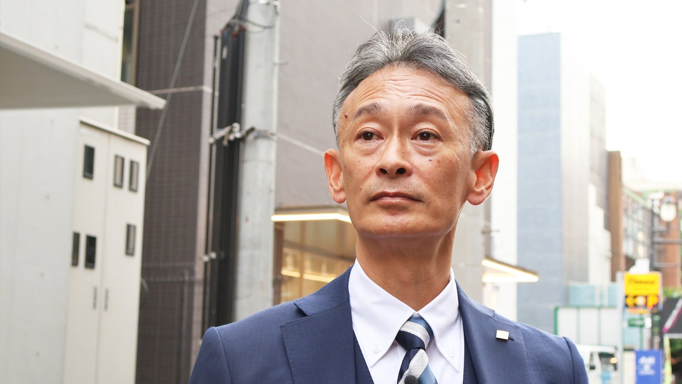 街中で遠くを見つめる和田洋FPの写真